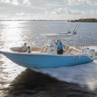 A man and woman riding a blue boat on the water.